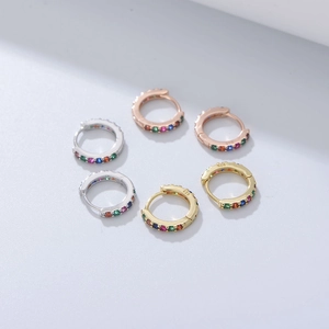 Close-up of S925 silver, gold, and rose gold earrings with multi-colored zircons