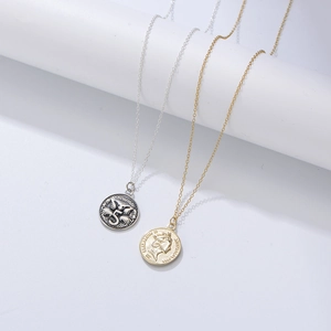 Gros plan sur un collier pièce vintage en argent S925 avec le portrait de la reine Elizabeth