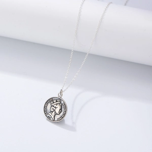 Collier avec pendentif pièce Elizabeth II en argent sterling S925 vintage sur support blanc