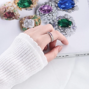 Detail of s925 silver ring featuring pink zirconia stones on a hand with soft knit sweater