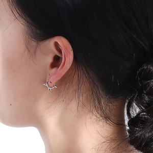 Dettaglio di orecchini a cerchio in argento S925 con punte a cono stile punk rock