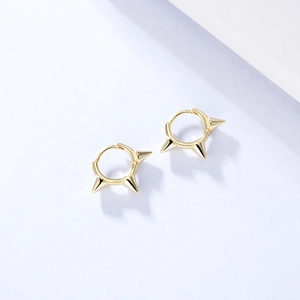 Dettaglio macro di orecchini punk in argento 925 placcati oro con tre punte coniche