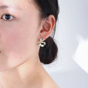 Close-up of elegant silver twisted geometric stud earring on model for a modern look