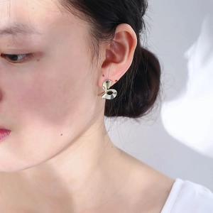 Minimalist gold-plated irregular spiral stud earrings for women on a female model