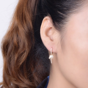 Gros plan d'une boucle d'oreille palmier doré sertie de zircons sur le mannequin