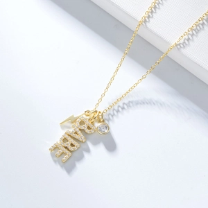 Détail du pendentif BABE avec cristaux, éclair et breloque ronde sur une chaîne dorée