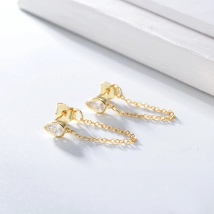 Macro detail of S925 sterling silver gold-plated teardrop zircon chain earrings
