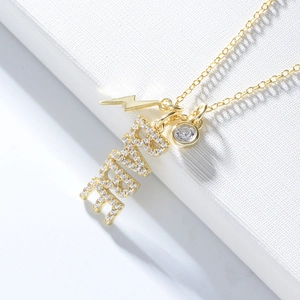 Détail macro du collier en argent S925 doré avec breloque LOVE et pendentifs