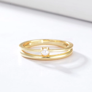Minimalist double-layer S925 silver gold ring with a central white pearl on white background