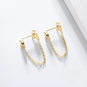 Macro detail of gold S925 silver teardrop earrings with zircon stone and fine metal chain