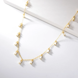 Detail of s925 silver necklace with sparkling baguette-cut zircon tassel pendants