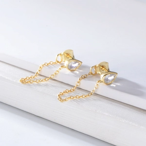 Macro view of gold S925 sterling silver stamp on pear-cut zircon chain earrings