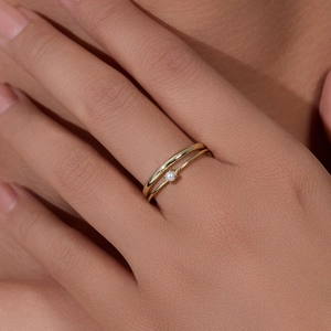 Minimalist double layer gold ring with white pearl accent shown on a female finger