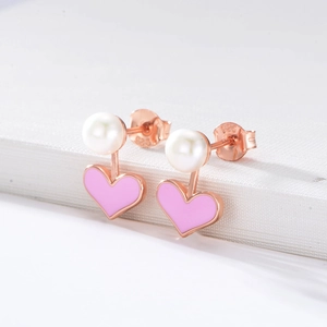 Macro shot of S925 sterling silver stamp on heart pearl earrings with pink enamel detail