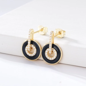 Macro view of S925 silver gold-plated stud earrings with black enamel and micro-pave zircons