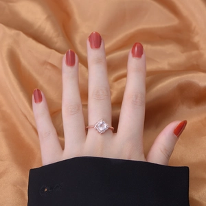 Rose gold silver ring featuring a square pink crystal and diamond halo on satin backdrop