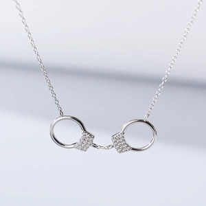 Détail macro du pendentif menottes en argent sterling avec sertissage micro-pavé