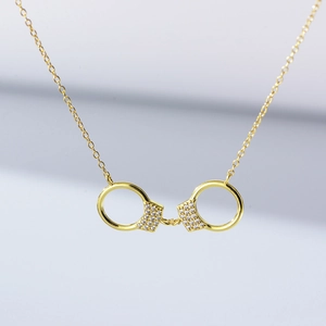 Gros plan du collier pendentif menottes en or 18 carats avec oxydes de zirconium brillants