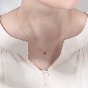 Détail du collier en argent s925 doré avec pendentif étoile noire sur le mannequin