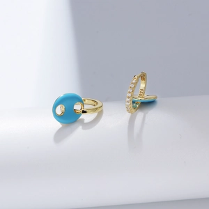 Detailed macro view of 925 silver gold-plated earrings with blue enamel and zircon inlay
