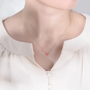 Collier minimaliste en argent S925 avec pendentif cœur rouge délicat porté par une femme