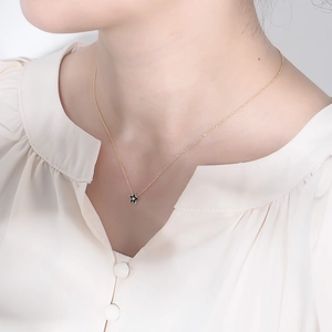 Détail du collier pendentif étoile dorée avec émail noir et petit accent de diamant