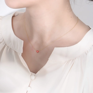 Détail du collier avec pendentif coeur en émail rouge et petit zircon sur chaîne dorée