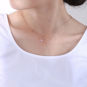 Détail du pendentif cœur en émail rose avec zircon sur fine chaîne dorée