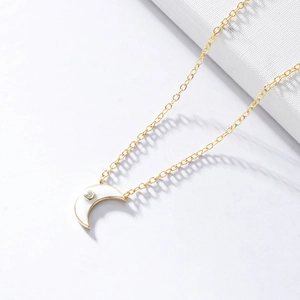 Detailed close-up of a gold s925 silver moon necklace with white enamel and zircon