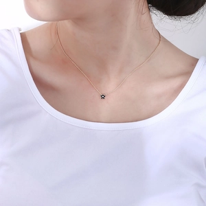 Gros plan d'un collier avec pendentif étoile dorée et émail noir sur un mannequin