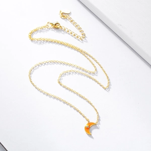 Macro shot of silver crescent moon pendant with orange gradient enamel and zircon inlay