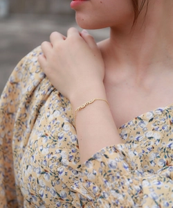 Close-up of a gold s925 silver Mama bracelet with zircon stones worn by a model