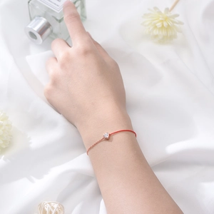 Minimalist red cord bracelet with a heart-shaped zircon pendant in rose gold finish