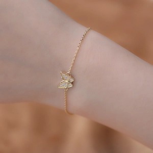 Macro shot of gold butterfly bracelet featuring clear cubic zirconia pavé stones