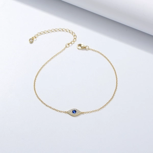 Golden Evil Eye bracelet with zircon micro-paving and blue center stone on white background