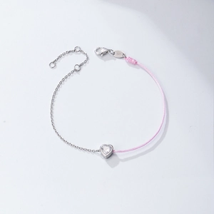 Macro shot of 925 sterling silver stamp on heart-shaped pink braided cord bracelet