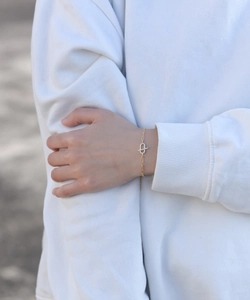 Close-up of gold paperclip chain bracelet with interlocking pavé zircon circles