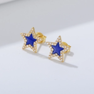 Macro shot of gold-plated star studs with blue enamel and micro-set cubic zirconia