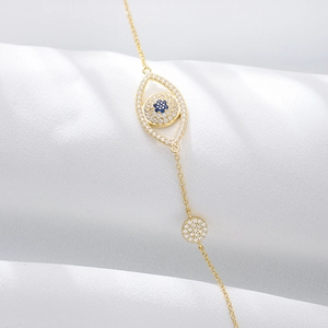 Close-up of golden Evil Eye bracelet featuring blue gems and shimmering zircon accents