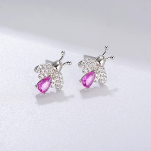 Detailed macro shot of silver bee earring featuring a pink pear-cut gem and zircon wings