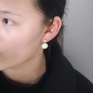 Macro shot of s925 silver vintage earrings with white shell stone and zircon details