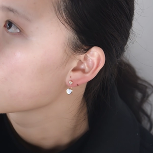 Boucles d'oreilles cœur en argent S925 avec nacre blanche et zircons sur modèle
