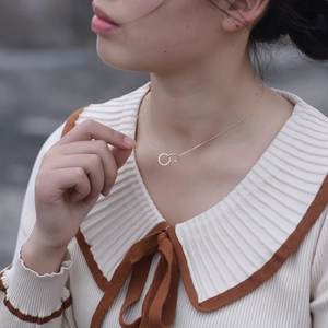 Detail of interlocking double circles necklace with crystal pavé on female model