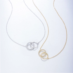 Detail of interlocking S925 silver double circle necklaces in gold and silver finish