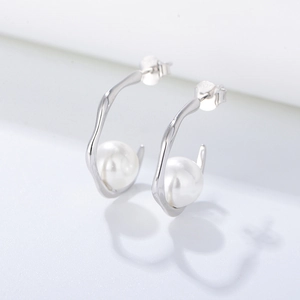 Macro shot of S925 sterling silver C-shape earrings with glossy white pearls