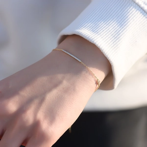 Close-up of minimalist gold s925 silver bracelet with sparkling zircon bar detail