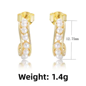 Detail of S925 silver hallmark and six white pearls on golden C-shaped hoop earring