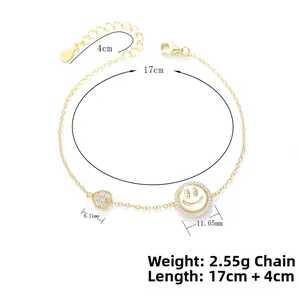 Détail d'un bracelet en argent doré avec cœur en zircon, smiley et guide des tailles