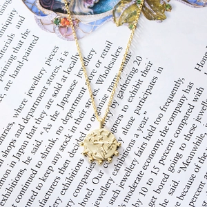 Vintage S925 sterling silver gold plated coin pendant necklace on a lifestyle magazine