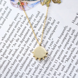 Vintage S925 sterling silver gold plated coin necklace on a magazine page background